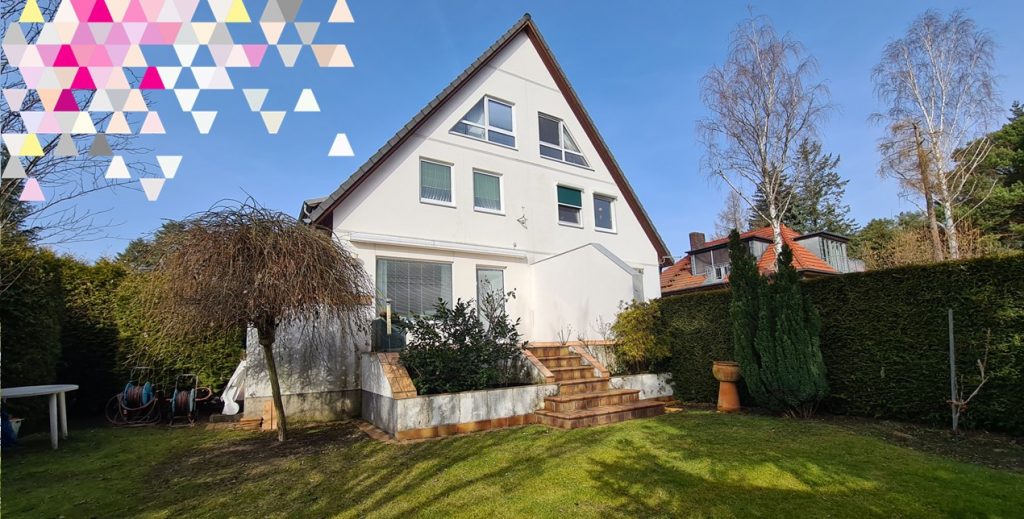 Modernes Einfamilienhaus mit weißem Giebel, großen Fenstern und gepflegtem Garten