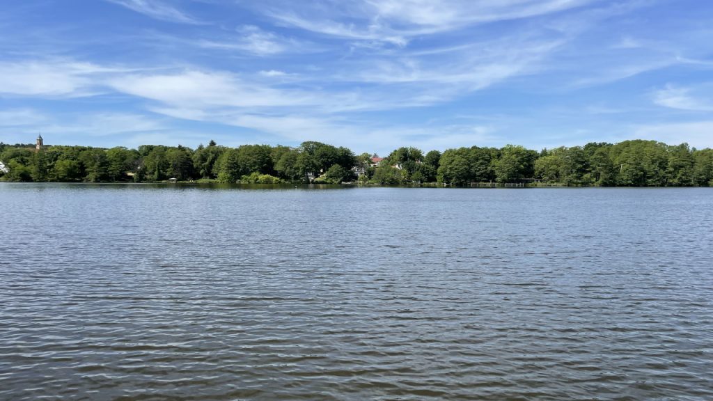 Bauersee in Woltersdorf bei Berlin mit Wasserfläche und bewaldetem Ufer im Hintergrund