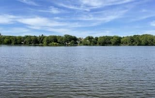 Bauersee in Woltersdorf bei Berlin mit Wasserfläche und bewaldetem Ufer im Hintergrund
