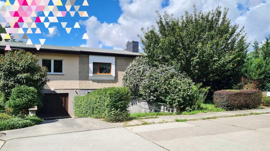 Einfamilienhaus mit Vorgarten, Hecke, Sträuchern und Einfahrt vor dem Haus